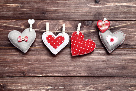 Fabric hearts hanging on brown wooden backgroundの写真素材