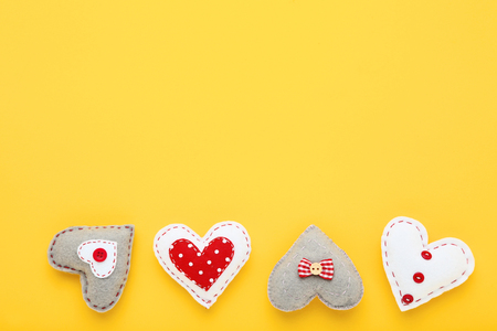 Colorful fabric hearts on yellow backgroundの写真素材
