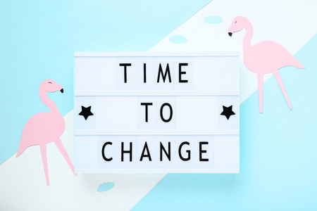 Lightbox with words Time To Change with paper flamingos on colorful background