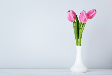 Bouquet of pink tulips in vase on wooden tableの写真素材