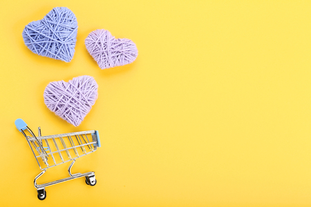 Shopping cart with rope hearts on yellow backgroundの写真素材