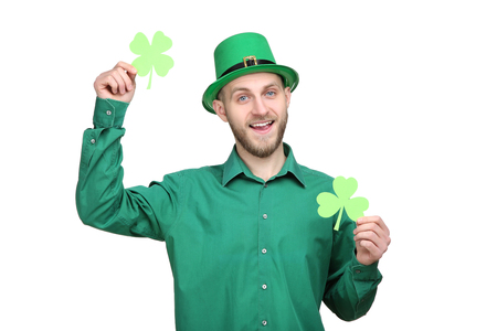 St. Patrick's Day. Young man wearing green hat with paper clovers on white backgroundの写真素材