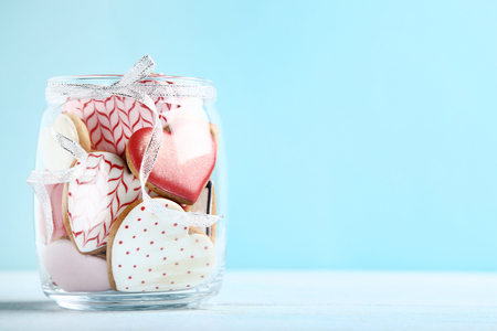 Valentine day cookies in glass jar on blue backgroundの写真素材