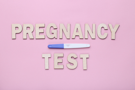 Pregnancy test with inscription on pink backgroundの写真素材