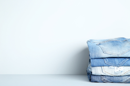 Stack of folded jeans on grey backgroundの写真素材