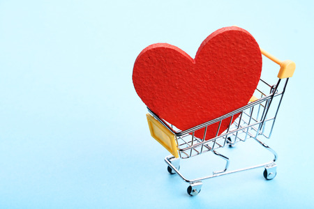 Shopping cart with red heart on blue backgroundの写真素材