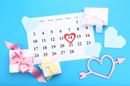 Valentine day calendar with paper hearts and gift boxes on blue backgroundの写真素材
