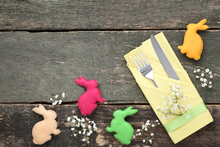 Kitchen cutlery with easter fabric rabbits and gypsophila flowers on wooden tableの写真素材