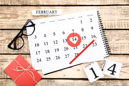 Valentine day calendar with gift box, glasses and wooden cubesの写真素材
