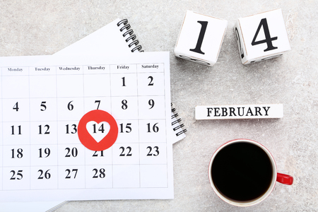 Valentine day calendar with wooden blocks and cup of coffeeの写真素材