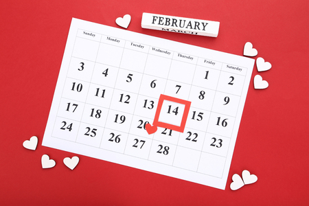 Valentine day calendar with wooden hearts on red backgroundの写真素材