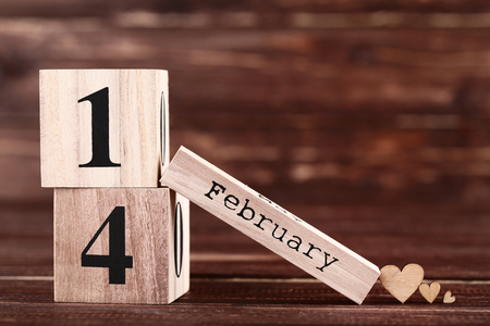 Valentine day on wooden blocks with brown heartsの写真素材