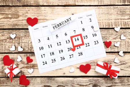 Valentine day calendar with hearts and gift boxes on wooden tableの写真素材