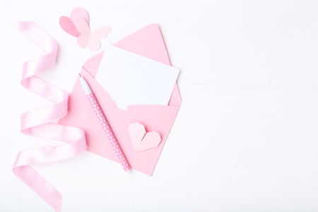 Pink paper hearts with envelope and pen on white backgroundの写真素材