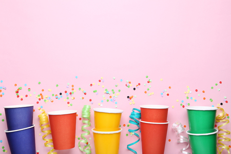 Colorful paper cups with confetti on pink backgroundの写真素材