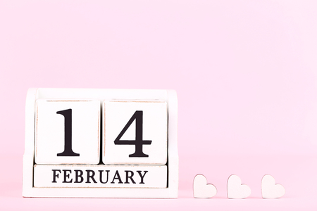 Valentine day on wooden blocks with white hearts