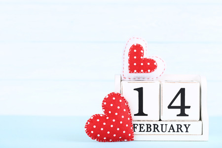 Valentine day on wooden blocks with red fabric hearts