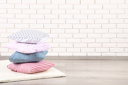 Soft colorful pillows on brick wall backgroundの写真素材