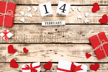 Valentine day on wooden blocks with hearts and gift boxes