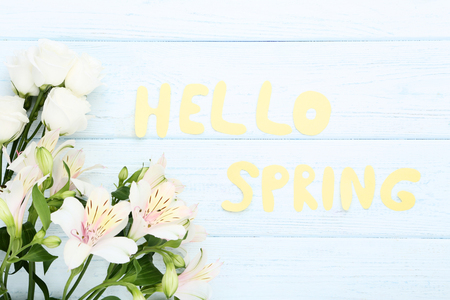 Alstroemeria and eustoma flowers with text Hello Spring on wooden tableの写真素材