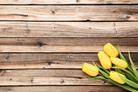 Bouquet of yellow tulips on brown wooden tableの写真素材