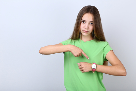Young girl with wrist watch on grey backgroundの写真素材