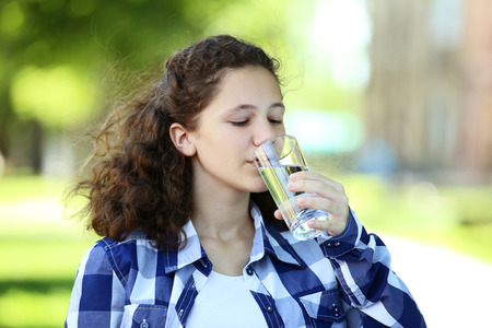 Young girl drinking water in the parkの写真素材