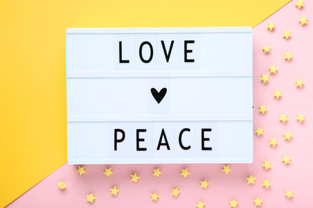 Lightbox with words Love Peace with paper stars on colorful backgroundの写真素材