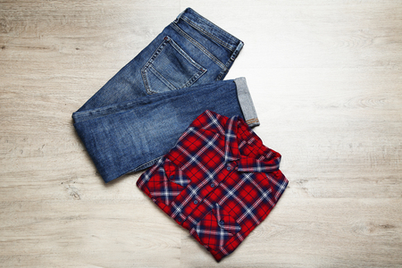 Folded shirt and jeans on wooden tableの写真素材