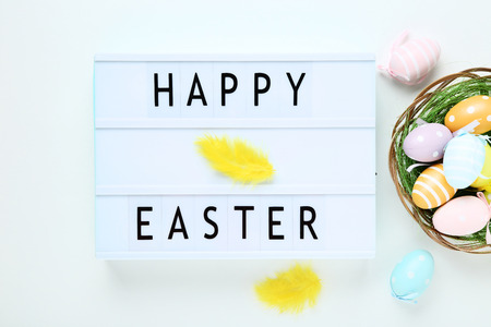 Lightbox with words Happy Easter with colorful eggs on white backgroundの写真素材
