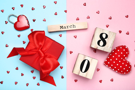 Women's Day on wooden calendar with gift box and red heartsの写真素材