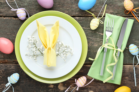 Kitchen cutlery with easter eggs and gypsophila flowers on wooden table