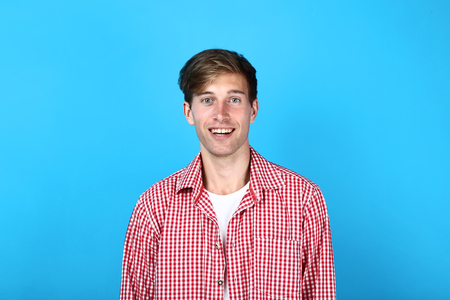 Beautiful young man in shirt on blue backgroundの写真素材