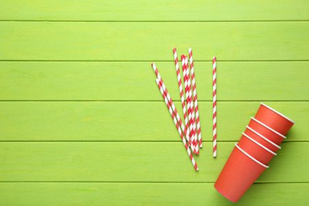 Red paper cups with straws on green wooden tableの写真素材