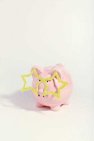 Piggybank with glasses in shape of star on white background. Minimalism conceptの写真素材