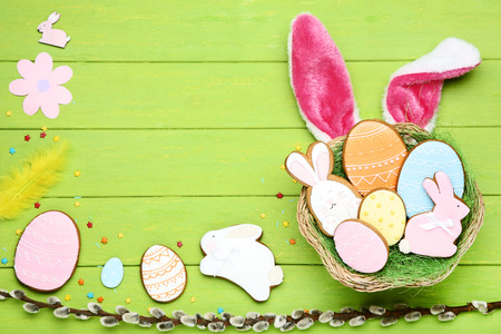 Easter gingerbread cookies with sprinkles and willow branch on wooden table