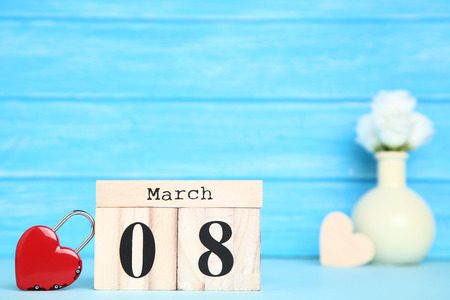 Women's Day on wooden calendar with heart shaped padlock on blue backgroundの写真素材
