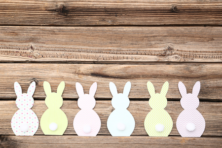 Easter paper rabbits on brown wooden tableの写真素材