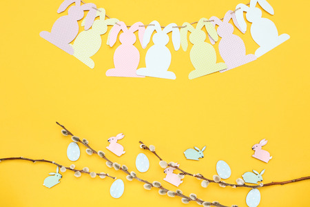 Easter rabbits with willow branches on yellow backgroundの写真素材