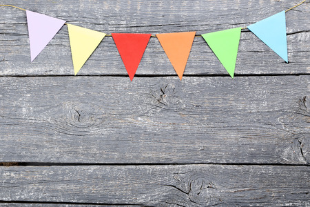 Colorful paper flags hanging on wooden backgroundの写真素材