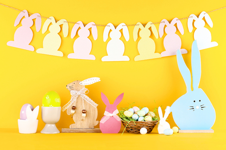 Easter eggs with different rabbits on yellow backgroundの写真素材