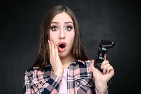 Beautiful girl with joystick on black background