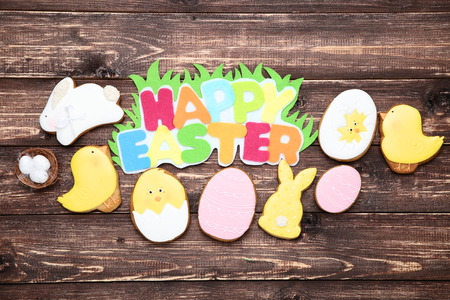 Gingerbread cookies with text Happy Easter on brown wooden tableの写真素材
