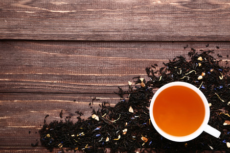 Cup of tea and dry leafs on wooden tableの写真素材