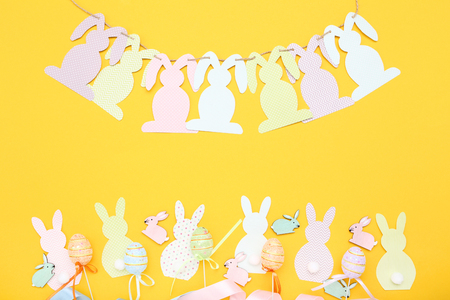 Easter rabbits with eggs on yellow backgroundの写真素材