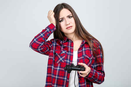 Beautiful girl with joystick on grey backgroundの写真素材