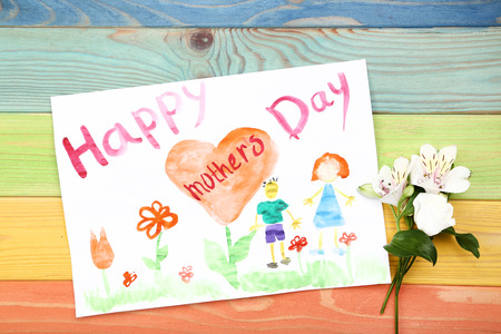 Greeting card for Happy Mothers Day with flowers on wooden tableの写真素材