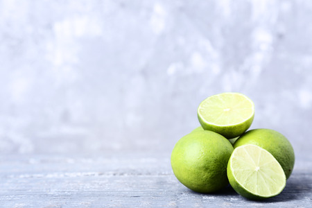 Ripe limes on grey wooden table