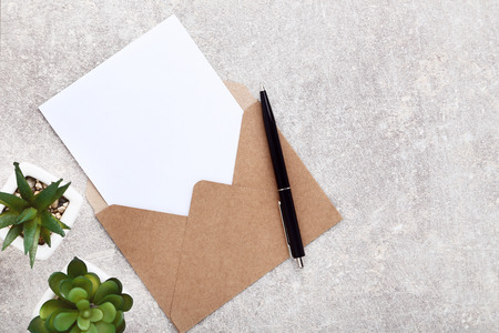 Blank paper with envelope and green plants on grey backgroundの写真素材