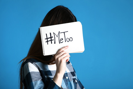 Woman holding paper with text Me Too on blue background